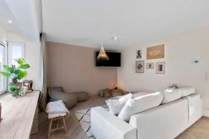 - un salon blanc avec un canapé blanc dans l'établissement Albane - modern 2 slaapkamer appartement, à Ostende