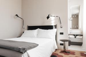 a bedroom with a white bed and a mirror at LA CASA DI LAURA in Valdobbiadene