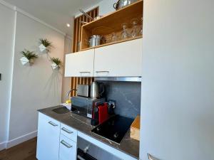 a kitchen with white cabinets and a microwave at Bree Street Apartment - Explore, Eat, Experience Cape Town in Cape Town +21 photos