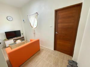 een woonkamer met een oranje bank en een deur bij Yourbed & House in Bangrak Beach