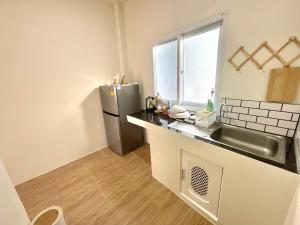 a kitchen with a sink and a refrigerator at Yourbed & House in Bang Rak Beach