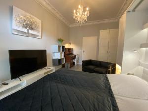 ein Schlafzimmer mit einem großen Bett und einem Fernseher in der Unterkunft Apartment Glasower 31 in Berlin