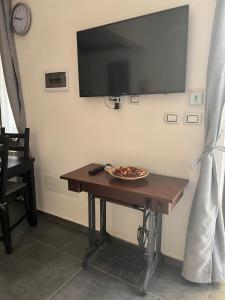 una mesa con un televisor en la pared con un tazón. en [FREE PARKING]Appartamento angolo di relax!!!, en Rivoli