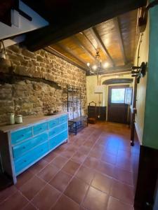 a kitchen with blue cabinets and a brick wall at Casa en aldea frente a la Sierra de el Sueve in Colunga