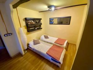 a small bedroom with a bed and a mirror at Casa en aldea frente a la Sierra de el Sueve in Colunga