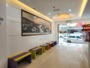 una sala d'attesa con sgabelli colorati in un negozio di Capital O 90939 Sandakan Central Hotel a Sandakan