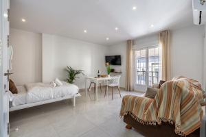 a bedroom with a bed and a table with a chair at Alojamiento Alcalá Centro in Alcalá la Real
