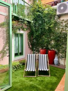 two deck chairs sitting on the grass in front of a building at Sintra Green Chalet Bed & Breakfast in Sintra