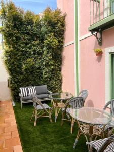 a patio with tables and chairs in front of a pink building at Sintra Green Chalet Bed & Breakfast in Sintra