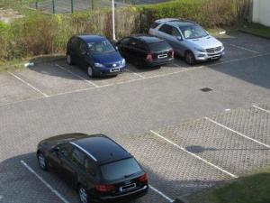 drei Autos parken auf einem Parkplatz in der Unterkunft Strandschlösschen I WE 11 / 674 in Kühlungsborn