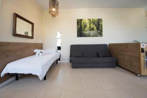 ein Schlafzimmer mit einem Bett und einem Sofa in der Unterkunft Apartamento familiar exterior en la costa de Zarautz - Oasis Palm in Zarautz