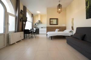 ein Wohnzimmer mit einem Bett und eine Küche in der Unterkunft Apartamento familiar exterior en la costa de Zarautz - Oasis Palm in Zarautz