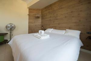 ein Schlafzimmer mit einem weißen Bett und einer Holzwand in der Unterkunft Apartamento familiar exterior en la costa de Zarautz - Oasis Palm in Zarautz