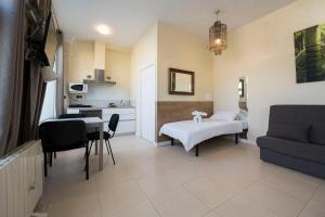 ein Wohnzimmer mit einem Bett und einem Tisch sowie eine Küche in der Unterkunft Apartamento familiar exterior en la costa de Zarautz - Oasis Palm in Zarautz