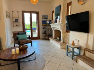 a living room with a fireplace and a flat screen tv at Villa Nova s.r Sea View in Porto Heli