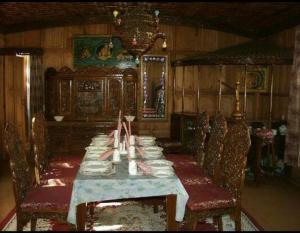 a dining room with a long table and chairs at Aliflaila Laila Group of Houseboats , Srinagar in Srinagar