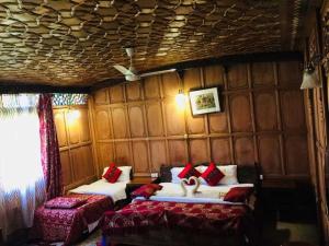 Habitación con 2 camas y almohadas rojas. en Aliflaila Laila Group of Houseboats , Srinagar, en Srinagar