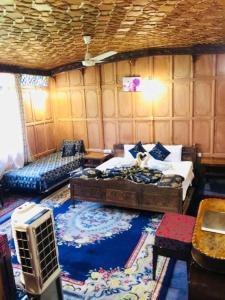 a room with a bed and a couch and a table at Aliflaila Laila Group of Houseboats , Srinagar in Srinagar