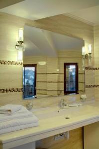 a bathroom with a sink and a large mirror at Hotel Bistrita in Durau