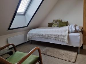 a attic bedroom with a bed and a chair at Mikkelborg Kro in Rødding