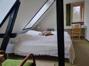 ein Schlafzimmer mit einem Bett im Dachgeschoss in der Unterkunft Mikkelborg Kro in Rødding