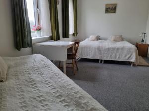 a bedroom with two beds and a desk and a window at Mikkelborg Kro in Rødding