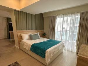 1 dormitorio con cama y ventana grande en 1BR Unit with Spectacular View Monaco Tower 1430A en Del Rosario