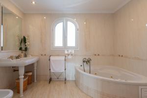 a white bathroom with a tub and a sink at La casita del Mar in Torremolinos