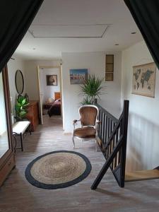 un salon avec un escalier et une chaise dans l'établissement Maison alsacienne à colombages dans cour privée avec jardin sur les remparts, à Bergheim