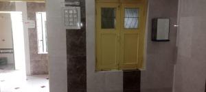 une porte jaune sur le côté du bâtiment dans l'établissement Om Bungalow, à Dwarka