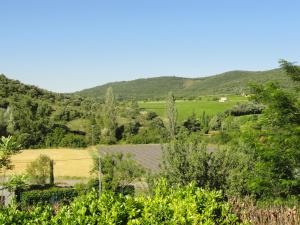 uma vista para uma quinta com montanhas ao fundo em Les Lauriers roses Vallon Pont d'Arc em Lagorce