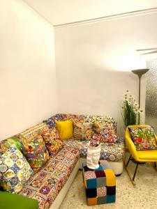 a living room with a colorful couch and a cat sitting on a stool at Casa Graziusa in Palermo