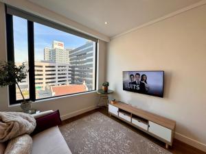a bedroom with a large window with a view of a city at Bree Street Apartment - Explore, Eat, Experience Cape Town in Cape Town