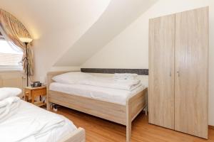 a bedroom with two beds and a wooden cabinet at Strandschloesschen-I-WE-19-682 in Kühlungsborn