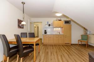 a kitchen and dining room with a table and chairs at Strandschloesschen-I-WE-21-684 in Kühlungsborn