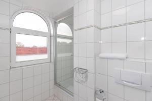a white bathroom with a window and a shower at Strandschloesschen-I-WE-21-684 in Kühlungsborn