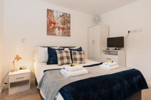 a bedroom with a bed with towels on it at Smart & modern Chester city-centre flat - Sleeps 2 in Chester