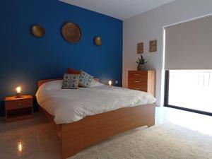 een slaapkamer met een bed met een blauwe muur bij Spacious Apartment in Marsalforn close to Seafront in Marsalforn