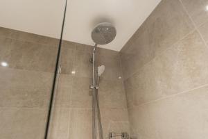 a shower with a shower head in a bathroom at Smart & modern Chester city-centre flat - Sleeps 2 in Chester