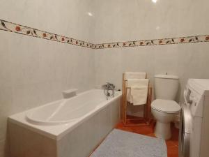 een witte badkamer met een bad en een toilet bij Spacious Apartment in Marsalforn close to Seafront in Marsalforn