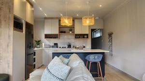 ein Wohnzimmer mit einem Sofa und einer Küche in der Unterkunft Executive Suites Brackenhurst in Alberton