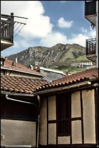 an old building with a mountain in the background at Tolosa un mundo de sensaciones in Tolosa