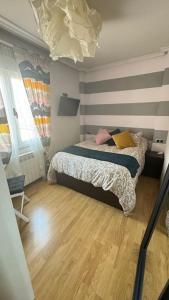 1 dormitorio con 1 cama y suelo de madera en Precioso ático con garaje gratis en Salamanca