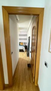 un pasillo con una puerta que conduce a un dormitorio en Precioso ático con garaje gratis en Salamanca