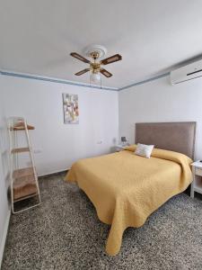 a bedroom with a bed and a ceiling fan at CASA EN EL CENTRO HISTORICO in Nerja
