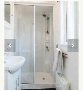 een witte badkamer met een douche en een wastafel bij Goederee 140 no companies recreational use only in Goedereede