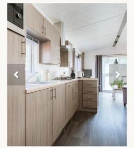 a kitchen with wooden cabinets and a large window at Goederee 140 no companies recreational use only in Goedereede