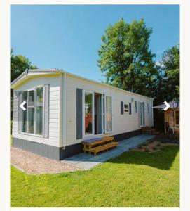 een klein wit huis met een picknickbank in een tuin bij Goederee 140 no companies recreational use only in Goedereede