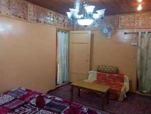 Zimmer mit einem Sofa, einem Stuhl und einem Tisch in der Unterkunft Houseboat New Jahangir And Morning Car in Srinagar