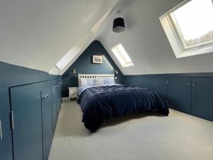 a bedroom with blue cabinets and a bed in a attic at Luxury farmhouse in secluded Cotswold valley in Uley